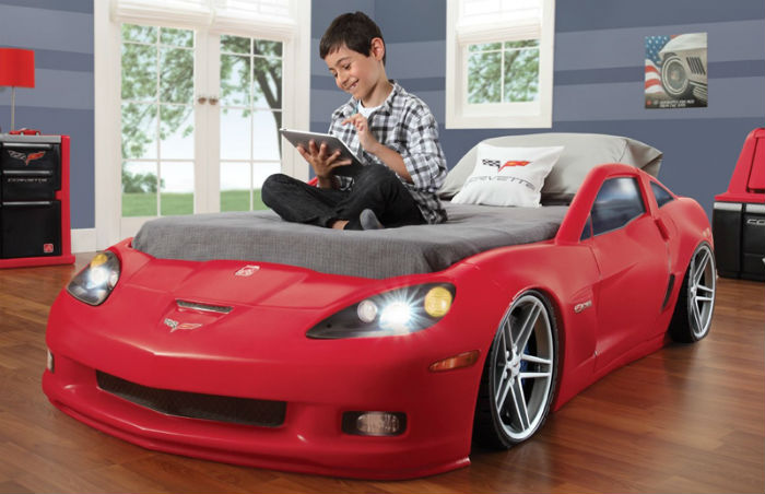 Мальчик сидит на кровати-автомобиле
